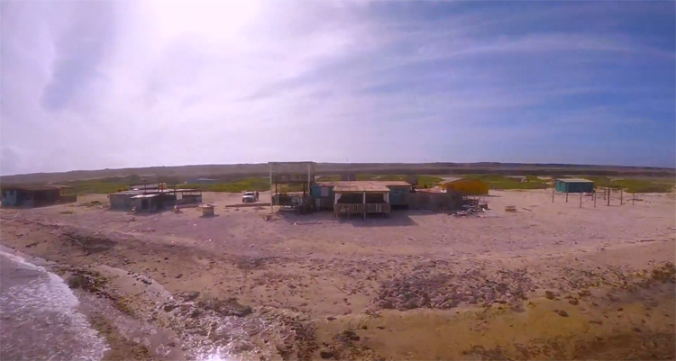 Vince Irie van SQG vliegt met drone over klein verlaten strand op Aruba